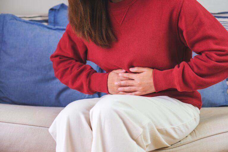 Closeup image of a sick woman suffering from stomachache, abdomi